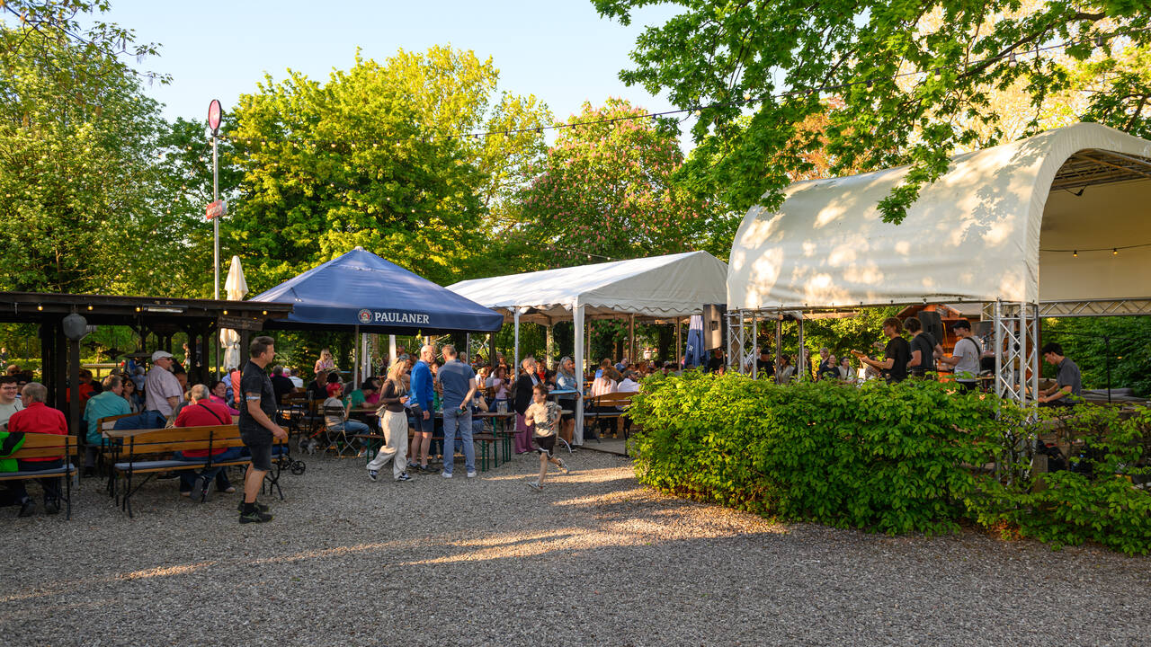 Biergarten Hochsaison im Bürgerpark Seelze: Bierbänke und Liegestühle unter alten Bäumen